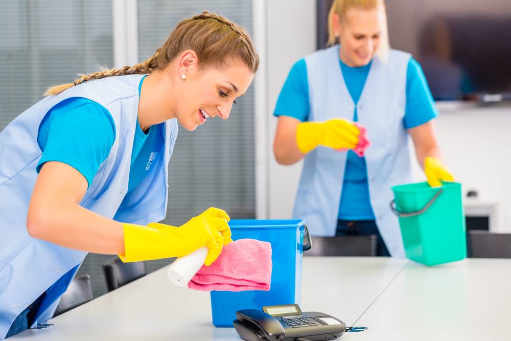 Two woman cleaning an office space